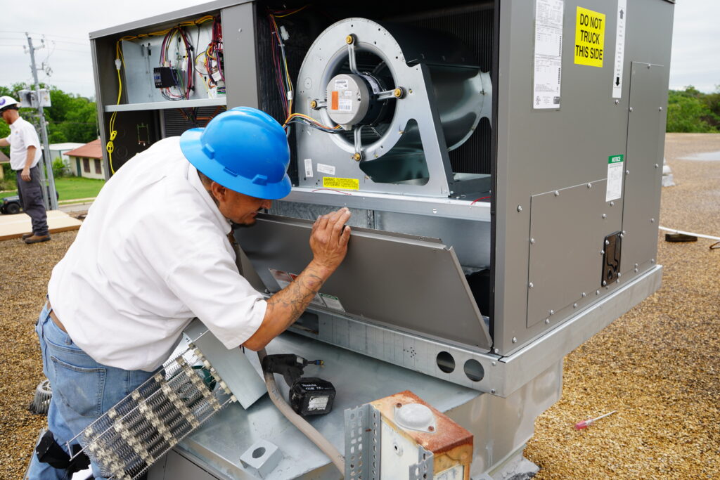 Dilmak technician servicing a commercial rooftop HVAC unit