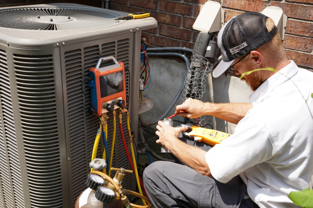 Dilmak technician diagnosing an AC unit with refrigerant gauges